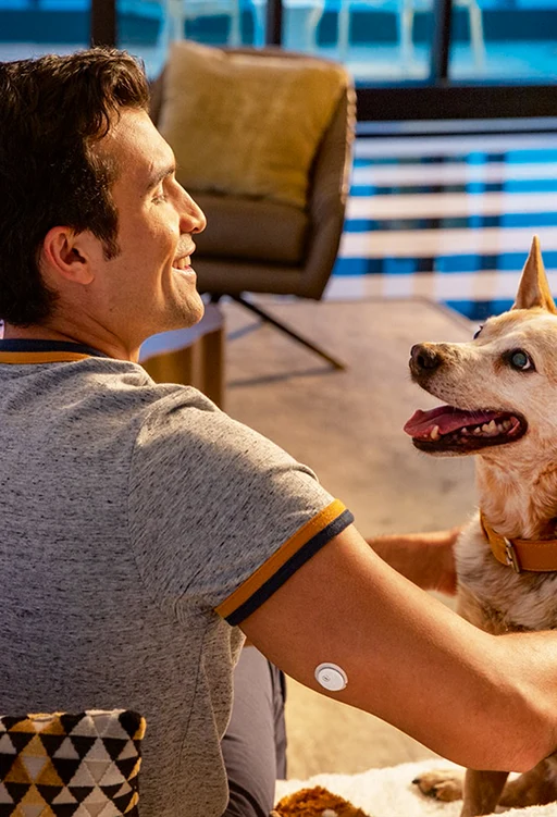 Mann mit Hund und FreeStyle Libre Sensor am Arm