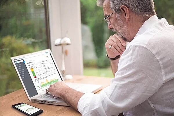 Mann sitzt vor einem Computer und schaut sich LibreView Berichte an