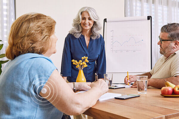 Eine Frau erklärt zwei Personen mit Diabetes etwas. Beide machen sich Notizen.