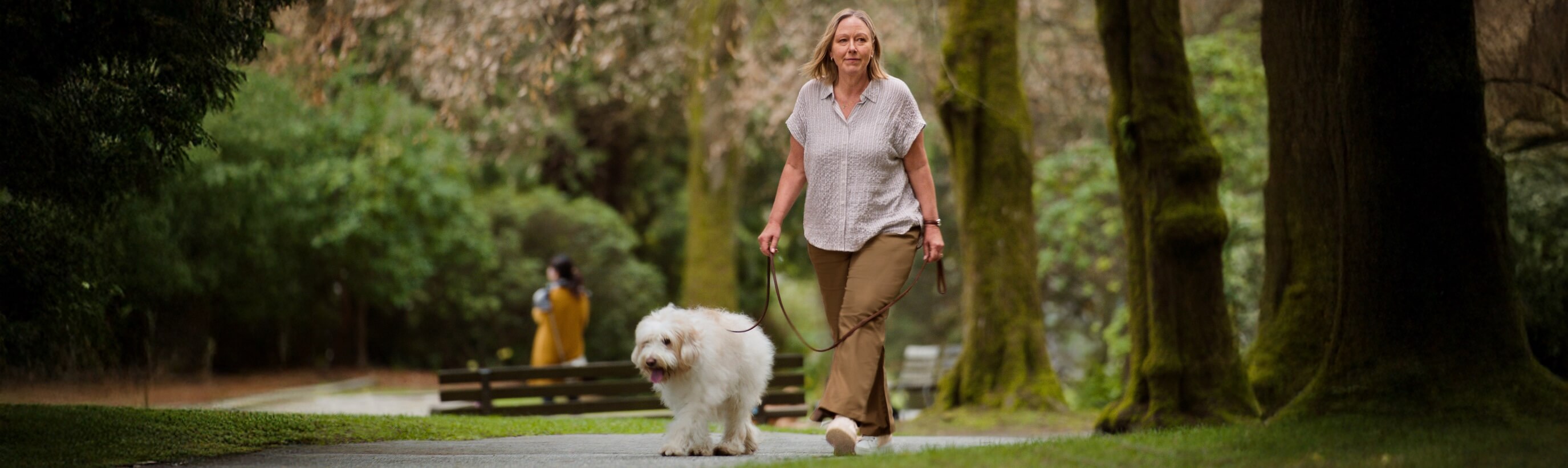 Frau mit Diabetes spaziert im Park mit ihrem Hund