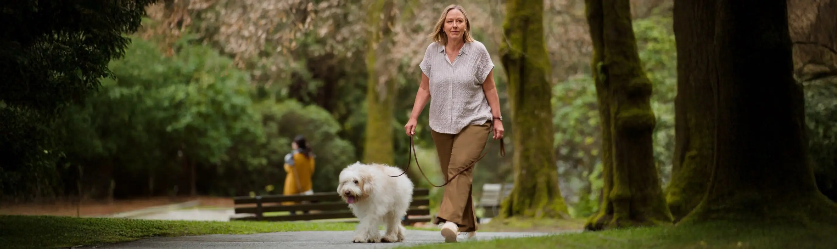Frau mit Diabetes spaziert im Park mit ihrem Hund